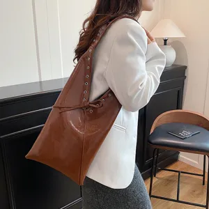 Detailed view of the vintage oil wax leather shoulder tote bag, stylish underarm rivet design.