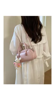 Détail de sac bowling en cuir rose, élégant sac à porté épaule avec charmante peluche.