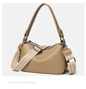 Detailed view of the stylish leather shoulder bag with wide woven strap and dual metal zippers.