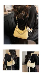 Detailed view of the stylish yellow gathered handle shoulder bag with cute horse charm accessory.
