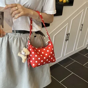 Chic red and white polka dot underarm bag with a cute bear pendant, stylish shoulder bag.