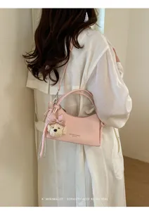 Pink minimalist shoulder bag detail featuring cute bear and bow keychain for daily wear.