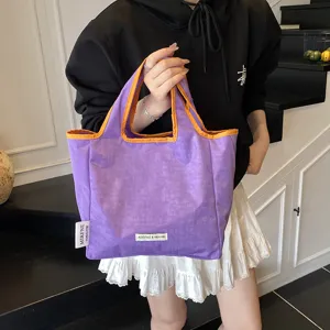 Minimalist purple canvas tote bag with contrast orange trim, casual portable shopping bag for women.