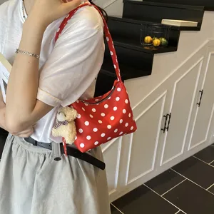 Red polka dot underarm bag with cute bear pendant, stylish shoulder handbag for women daily wear.