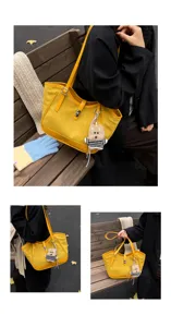 Vue détaillée du sac cabas en suédine jaune avec charm ours pour un look quotidien.