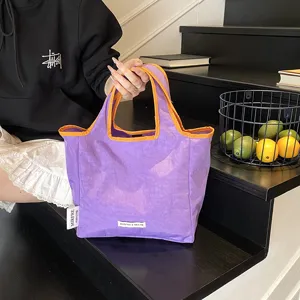 Detail view of stylish purple and orange tote bag, modern casual design for daily portable use.