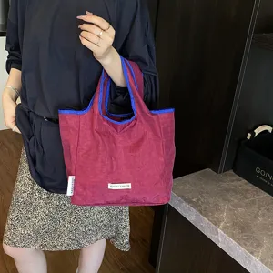 Casual folding tote bag with contrast blue handles, stylish shopping bag for daily use.