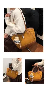 Détails du sac cabas en daim marron, texture douce, fermoir métallique et charm ours.