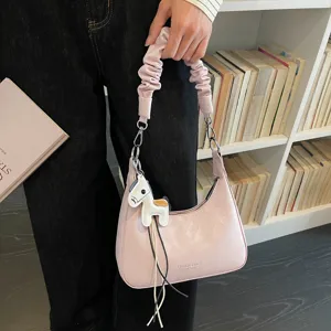 Detailed view of the pink shoulder hobo bag with scrunchie strap and cute horse charm.