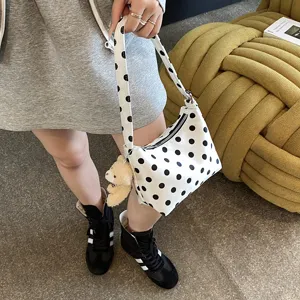 Chic white and black polka dot shoulder bag, casual underarm handbag with cute bear charm.