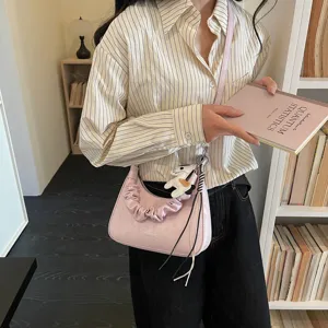 Pink hobo shoulder bag detail featuring scrunchie handle and cute pendant for daily commute.