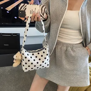Stylish black and white polka dot shoulder bag with cute bear pendant for women daily use.