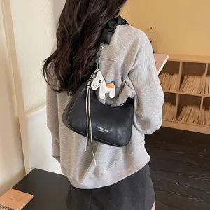 Detailed view of women black hobo shoulder bag with cute horse charm and stylish pleated strap.
