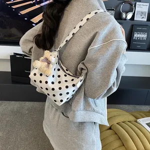 Chic polka dot canvas shoulder bag for women, casual underarm handbag with cute bear pendant.