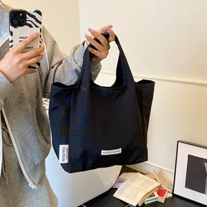 Detailed view of a black casual canvas tote bag, lightweight portable shopping handbag.