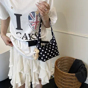 Chic black and white polka dot canvas shoulder bag with cute teddy bear pendant, trendy.