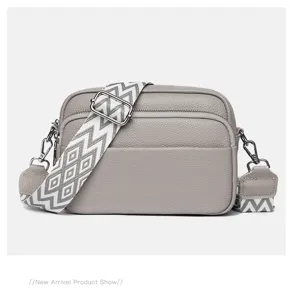 Detailed shot of the multi-layer leather crossbody bag featuring a wide geometric strap.
