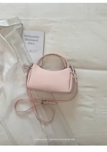 Close-up view of the pink minimalist shoulder bag, showing fine stitching and smooth leather texture.