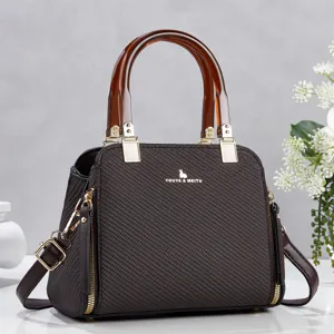Sac à bandoulière texturé marron foncé avec poignées en résine ambre et détails dorés.