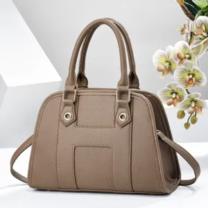 Sac à main coquillage classique marron grain litchi avec poignées et anneaux métalliques.