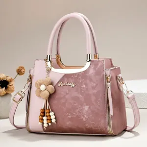 Pink color-blocked multi-layer handbag with flower pendant, elegant shoulder bag for women.
