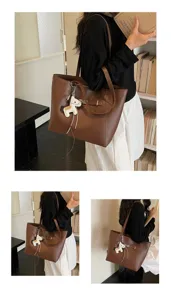 Brown leather tote bag with lock and horse charm, stylish spacious commuter shoulder bag.