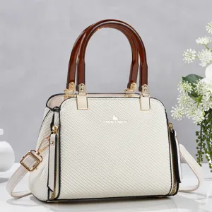 Vue détaillée du sac à bandoulière tissé élégant avec poignées écaille et détails dorés.