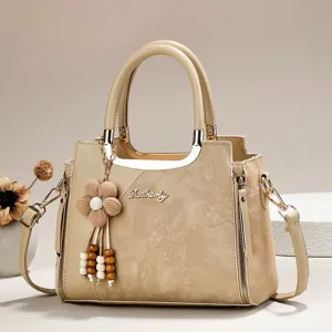 Beige stylish top handle handbag with floral pendant and multi-layer design for women detail view.