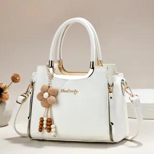 White PU leather handbag detail, featuring gold metallic handles and cute beaded flower pendant.