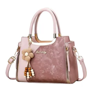 Stylish pink color block women handbag with floral charm and metal handles for daily use.