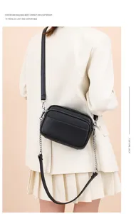Close-up detail of the stylish black leather crossbody bag featuring a chic chain strap worn.