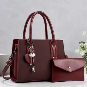 Burgundy women commuter handbag set with shoulder strap and chic key charm detail.