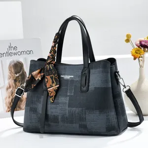 Elegant women's leather tote bag with printed pattern and silk scarf accessory for daily commute.