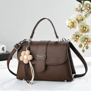 Vue détaillée du sac à bandoulière marron pour femme avec grain litchi et charmant pendentif.