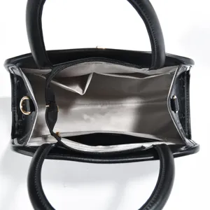 Vista dettagliata dell'interno della borsa in pelle nera con scomparti multipli e tasca zip.