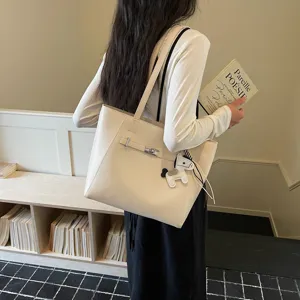 Elegant beige PU leather tote bag with metal turn-lock closure and cute horse charm.