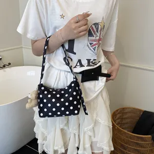 Black white polka dot shoulder bag for women, stylish underarm cloth bag with cute bear pendant.