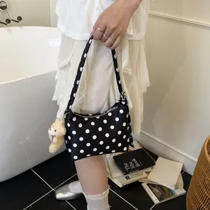 Black and white polka dot underarm bag with cute teddy bear charm for women daily fashion.