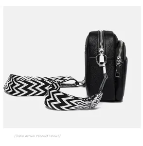 Black multi-layer leather crossbody bag with stylish patterned strap and metal zippers for women.