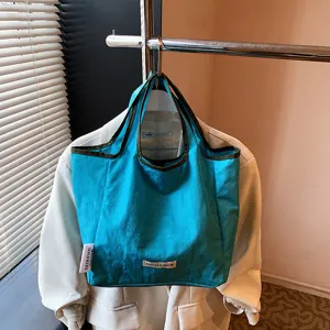 Foldable blue tote bag detail view, casual shopping handbag with contrast piping.