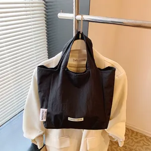 Minimalist black canvas tote bag for women, casual daily handbag, portable foldable shopping bag.