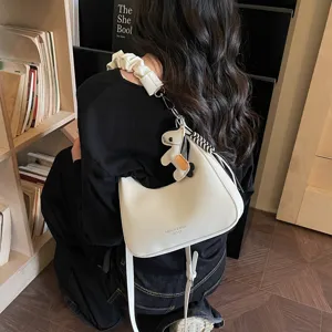 White hobo shoulder bag with scrunchie strap and cute pendant for women, stylish commuting handbag.