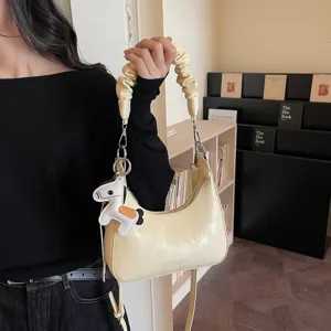 Stylish yellow hobo shoulder bag with gathered handle and cute horse charm for women.