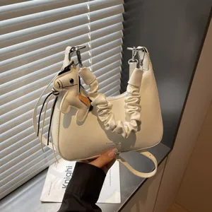 Stylish minimalist white shoulder bag with pleated handle and cute horse charm for daily commuting.