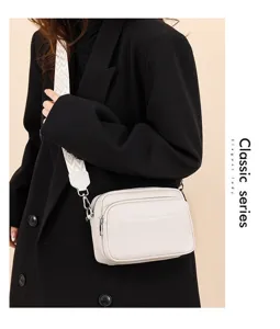 Detailed view of the multi-layer leather crossbody bag showing dual zipper compartments.