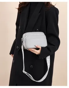 Detailed view of women's multi-layer crossbody shoulder bag in grey leather with patterned strap.