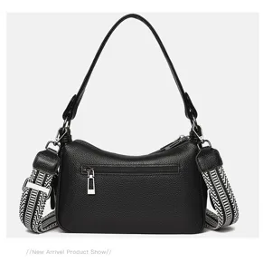 Detailed view of black genuine leather saddle bag with wide strap and back zipper pocket.