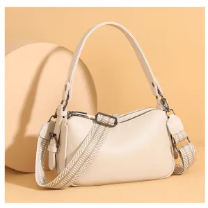 Detail view of stylish genuine leather saddle shoulder bag for women with wide strap.