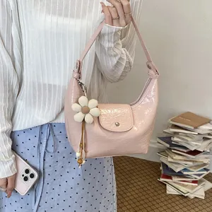 Borsa a spalla hobo dumpling in pelle verniciata rosa con ciondolo a fiore per le donne