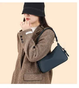 Dark blue leather shoulder bag, stylish hobo pillow bag detail view showing texture and strap.